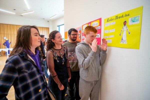 Students from the AI in My Life programming discussing final project posters